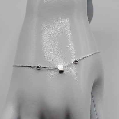 Minimalist free floating silver cube with silver ball accents