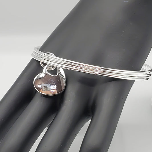 .925 Sterling Silver 3 tier bangle bracelet accented by a sterling silver heart charm.