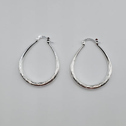 .925 Sterling Silver oval shaped textured hoop earrings.