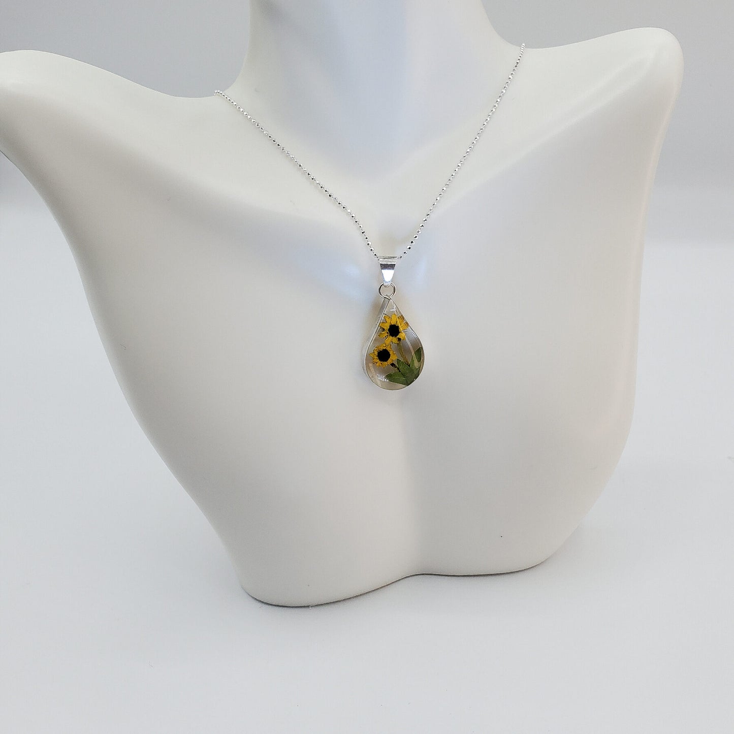 Resin pendant with sunflowers on a solid silver chain.