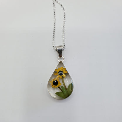 Resin pendant with sunflowers on a solid silver chain.