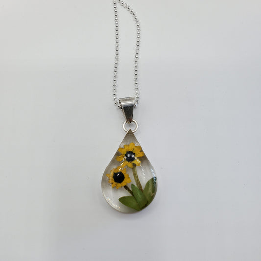 Resin pendant with sunflowers on a solid silver chain.