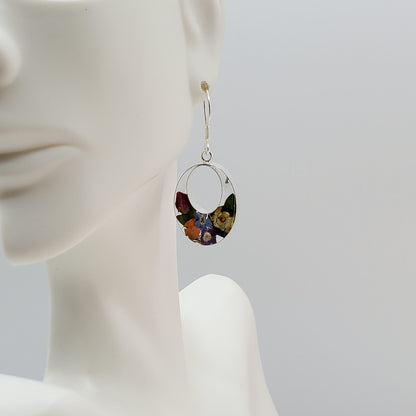 Oval dangle earrings with multi colored flowers.