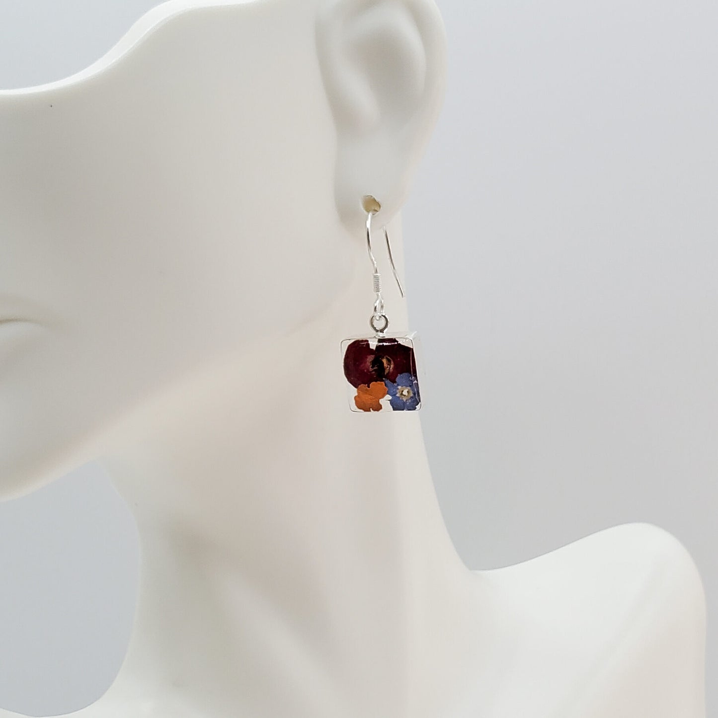 Square dangle earrings with multi colored flowers.