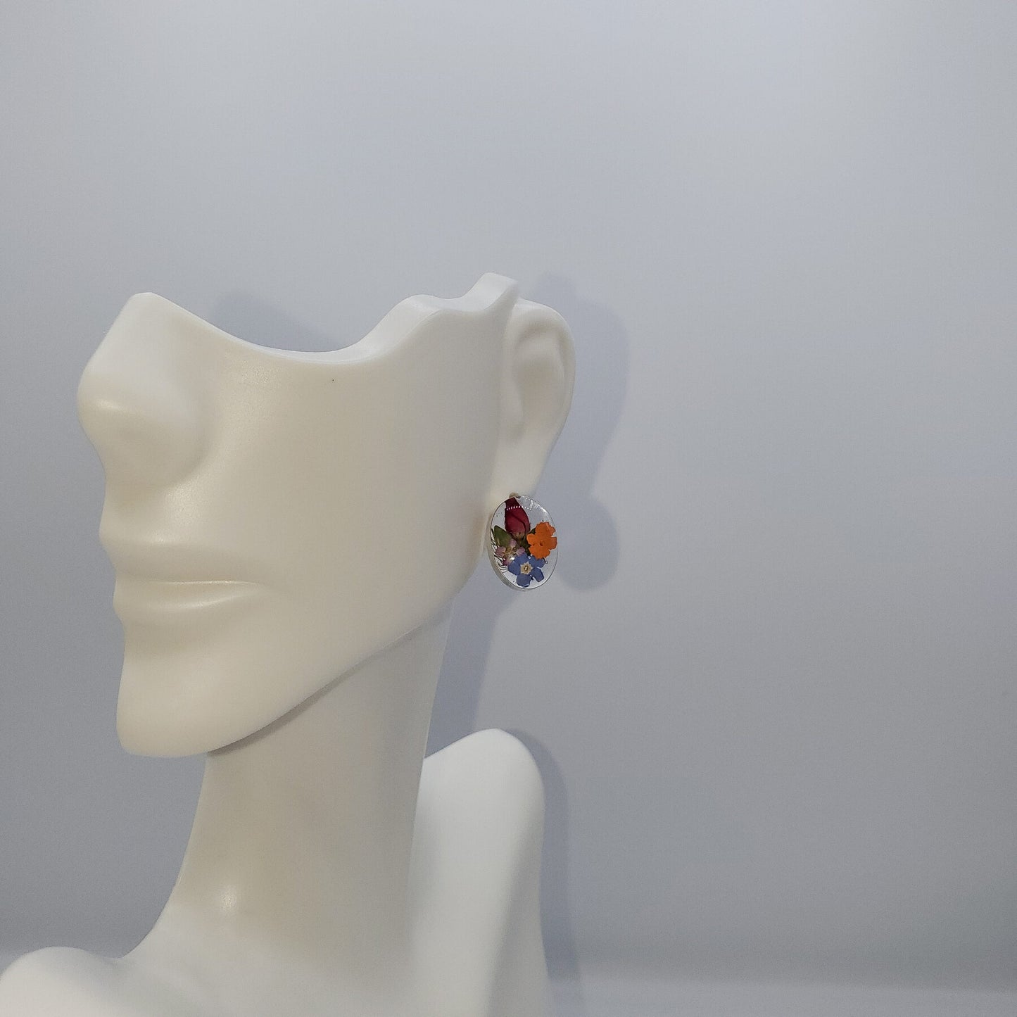 Oval post earrings filled with multi colored flowers.