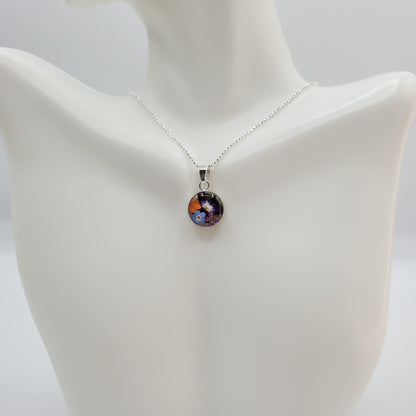 Small round resin pendant with real multi colored flowers.