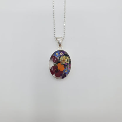 Oval resin pendant with delicate multi colored flowers