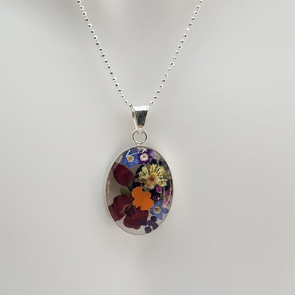 Oval resin pendant with delicate multi colored flowers