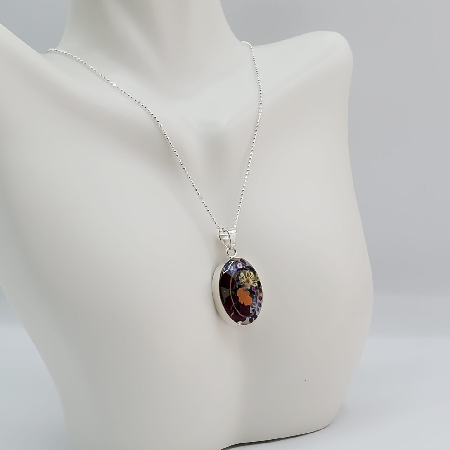 Oval resin pendant with delicate multi colored flowers